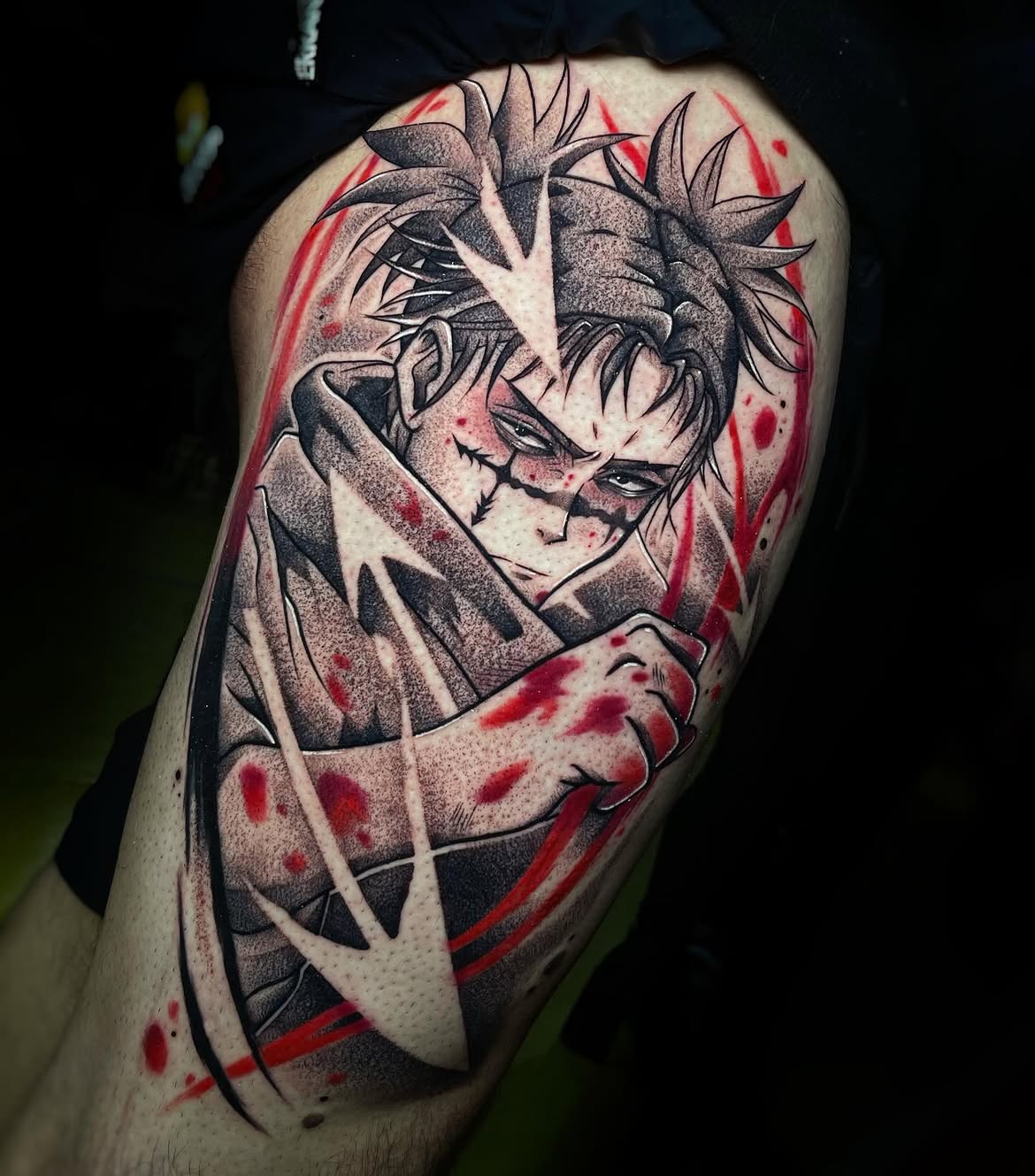 Tatuaje de personaje anime con cortes y salpicaduras rojas sobre el muslo, estilo dark