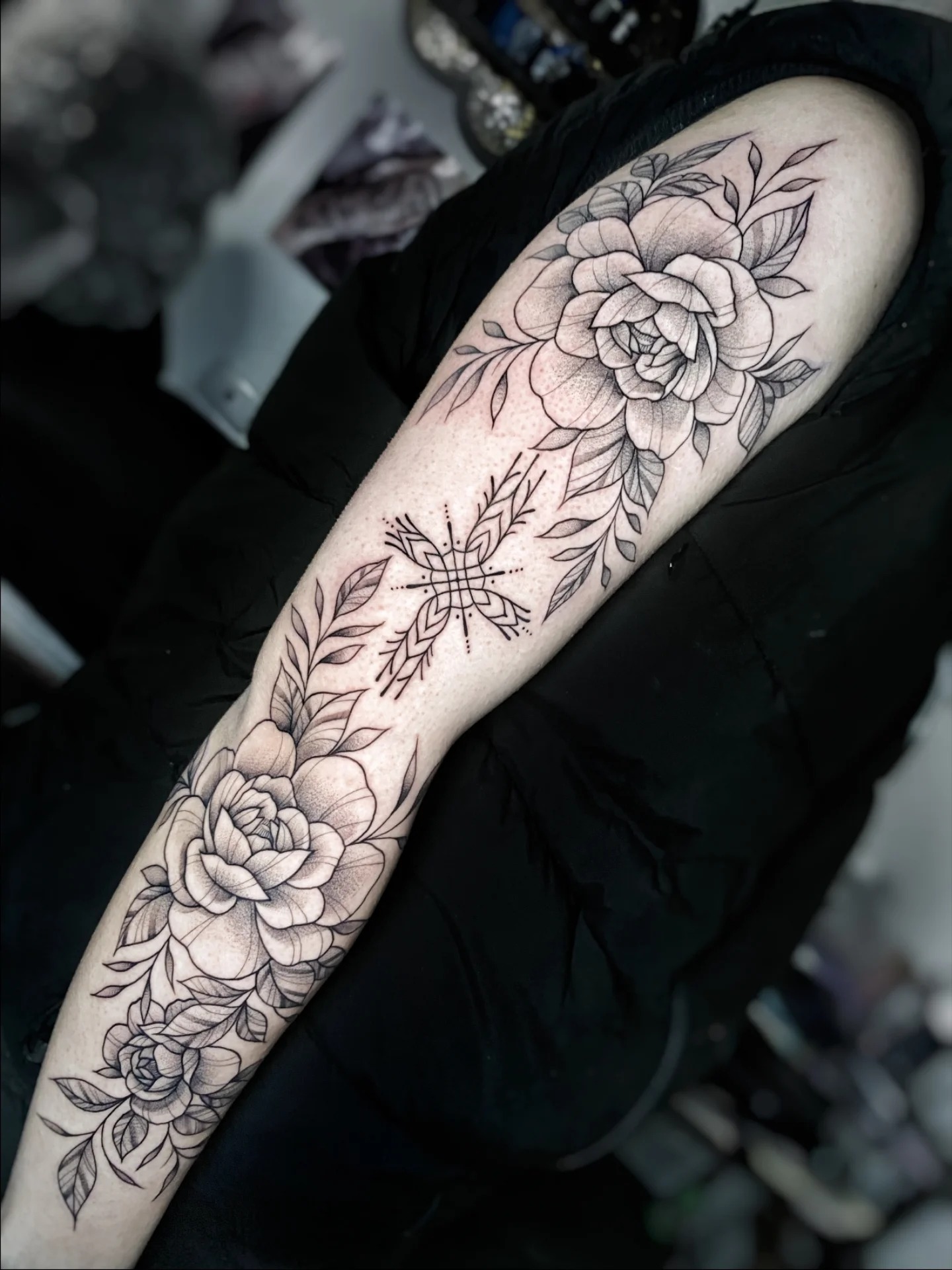 Manga floral de rosas y hojas con mandala en fine line y puntillismo sobre el brazo